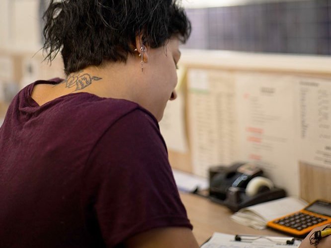 Eine junge Frau im Büro erstellt eine Liste auf Papier