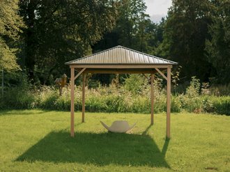 Ein hölzerner Gartenpavillon mit grauem Metalldach steht auf einer grünen Wiese. Darunter befindet sich ein weißer Hängesessel. Im Hintergrund sind dichte Bäume und Sträucher zu sehen.