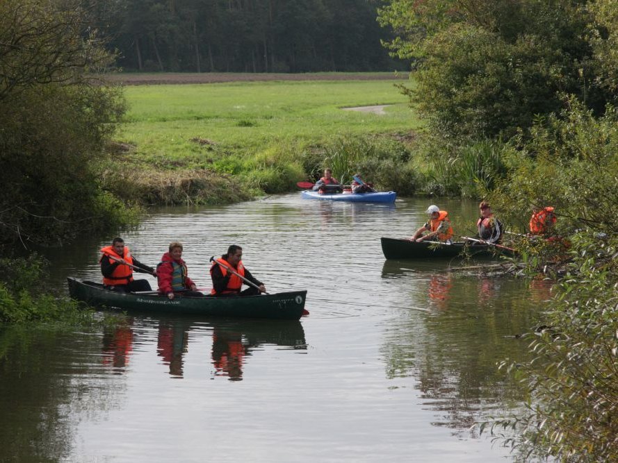 Kanufahrt auf einem Fluss - alle tragen Schwimmweste